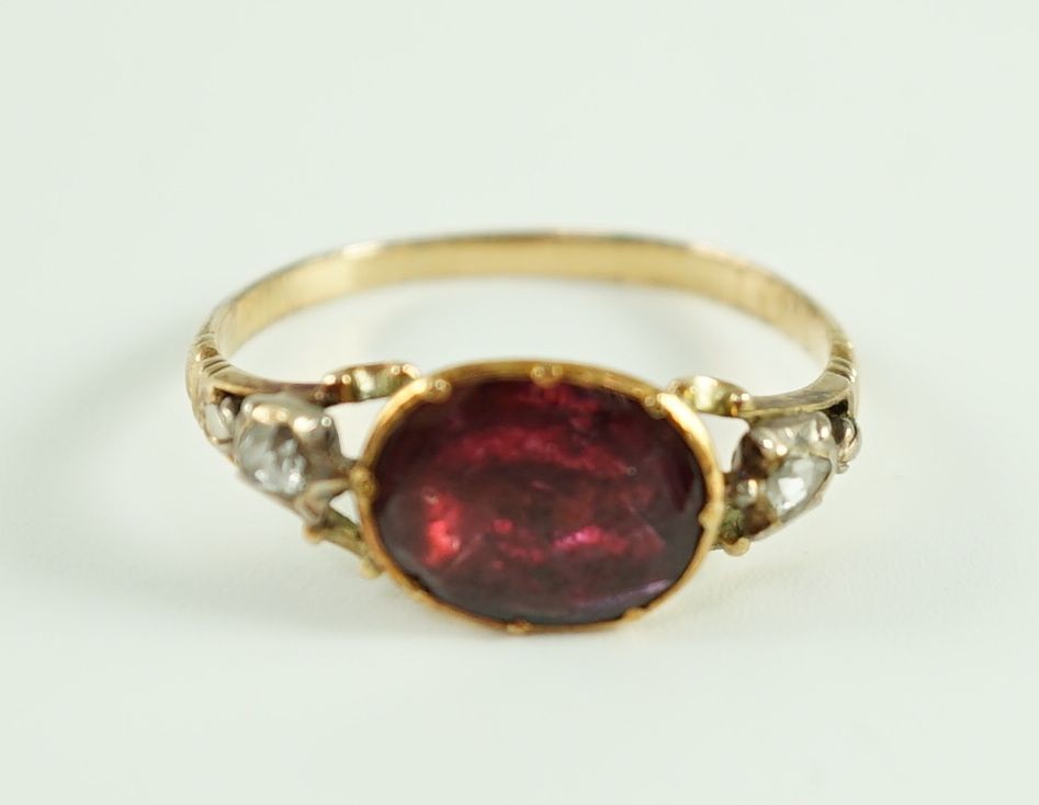 A George III gold, foil backed garnet and rose cut diamond set three stone ring